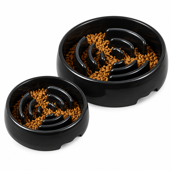 Two black slow feeder bowls filled with kibble on a white background