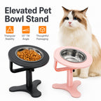 Black and pink elevated pet bowl stands with stainless bowls beside a fluffy cat